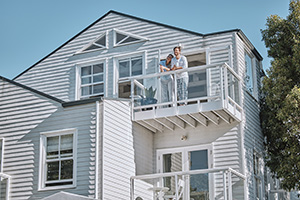 Couple on the balcony of their dream home purchased from a list of beautiful homes for sale in Lavallette