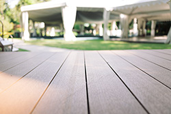 Ground-level view of a composite deck built by Barnegat Light deck contractors with white tents in background